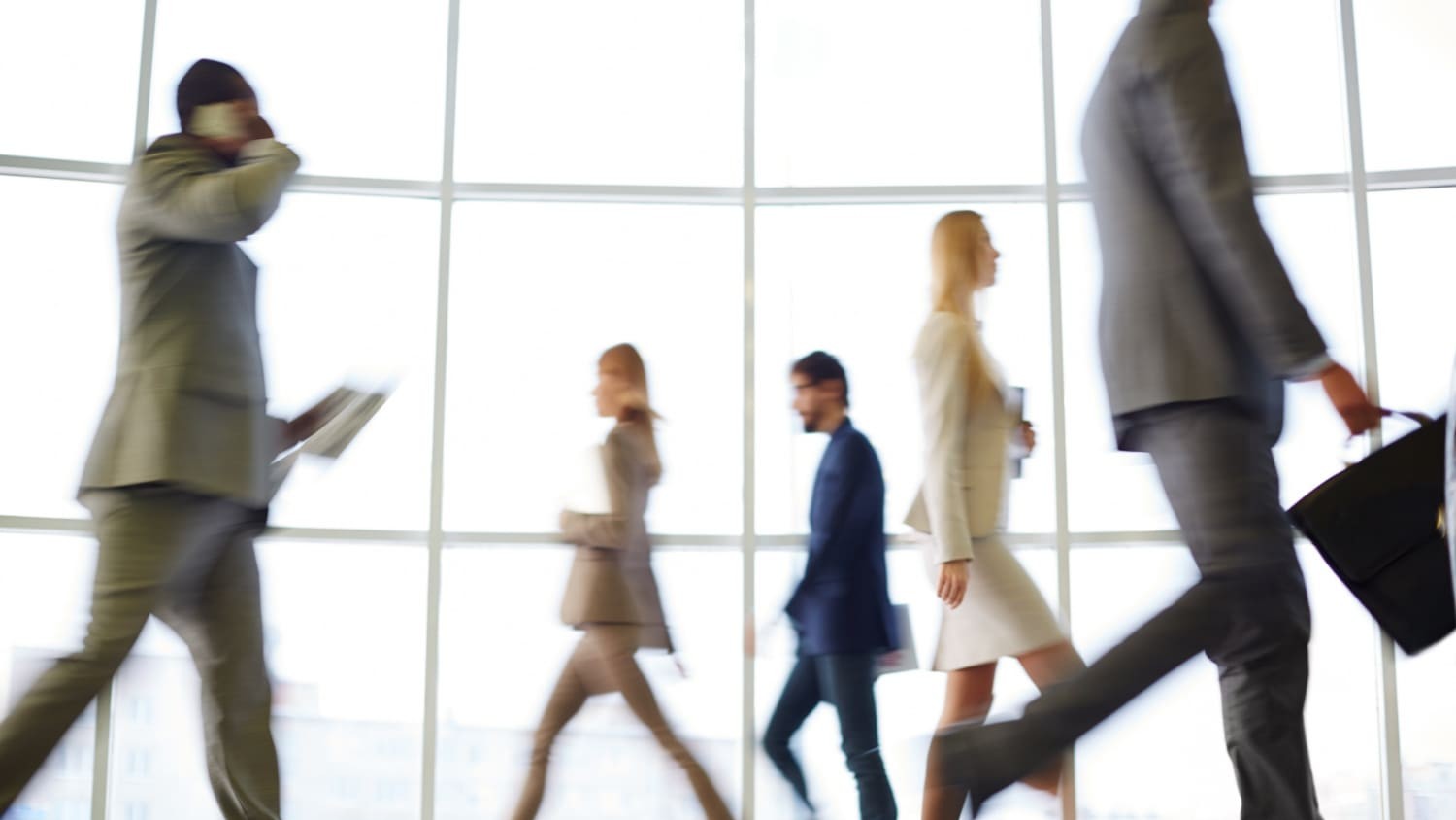 Zakenmensen lopen gehaast voorbij elkaar, illustratie van verandering en dynamiek in werkleven