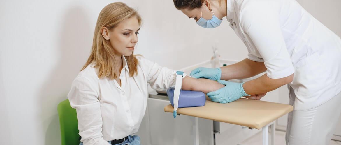 op deze foto zie je een voorbeeld van hoe je de bloeddruk meet|afbeelding van een vrouw die op de juiste manier de bloeddruk meet