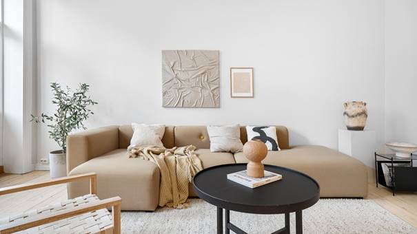 Woonkamer met rustige inrichting, natuurlijke materialen, zachte kleuren en minimalistische decoratie
