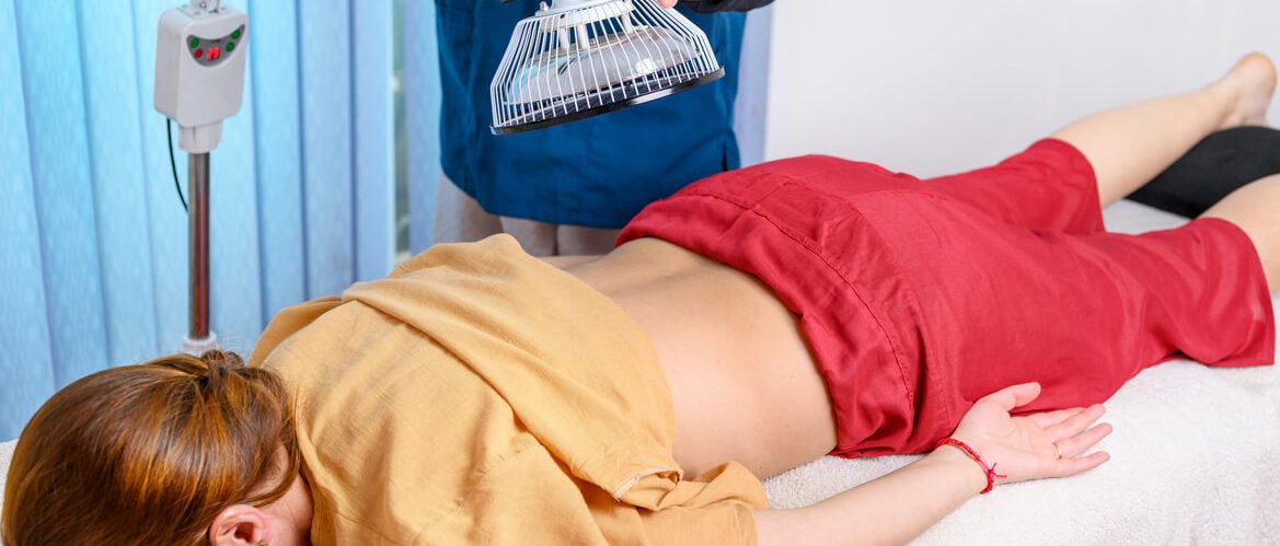 deze vrouw gebruikt een infrarood lamp voor haar rugpijn