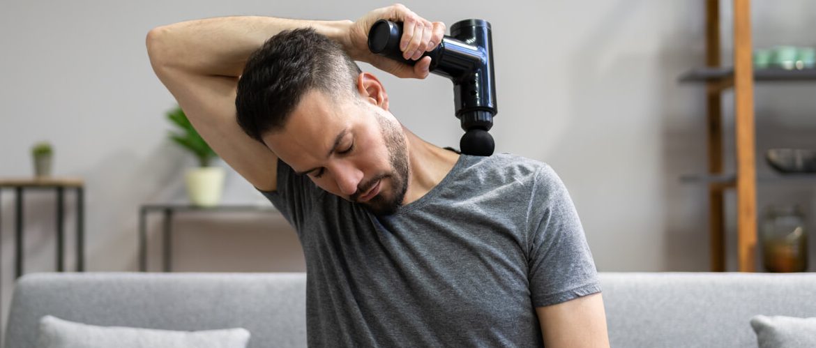 de man op deze foto ervaart de werking van een massage gun