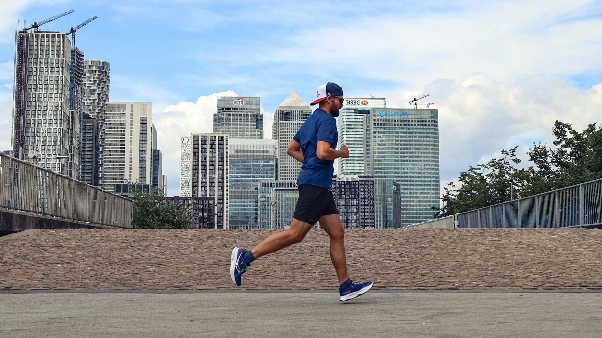 Man jogt in de stad langs moderne gebouwen en werkt aan zijn actieve leefstijl