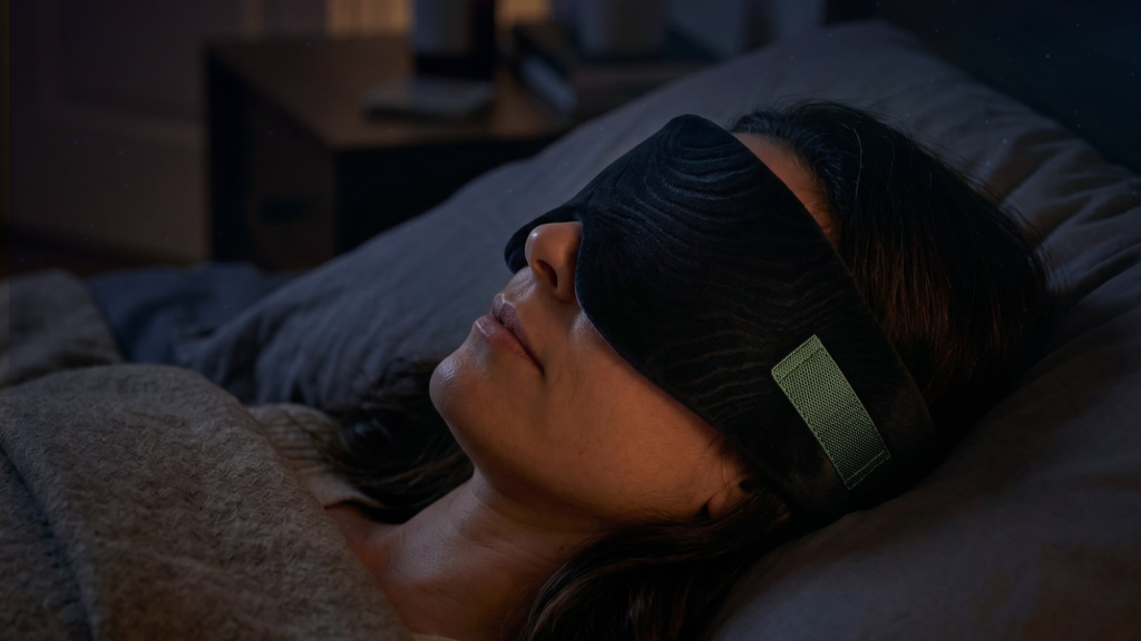 Persoon slaapt met zwart slaapmasker in donkere slaapkamer voor volledige verduistering tijdens de nacht