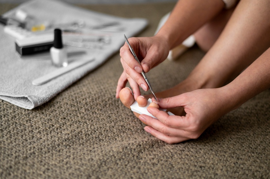 vrouw aan de slag met teennagels met pedicureset