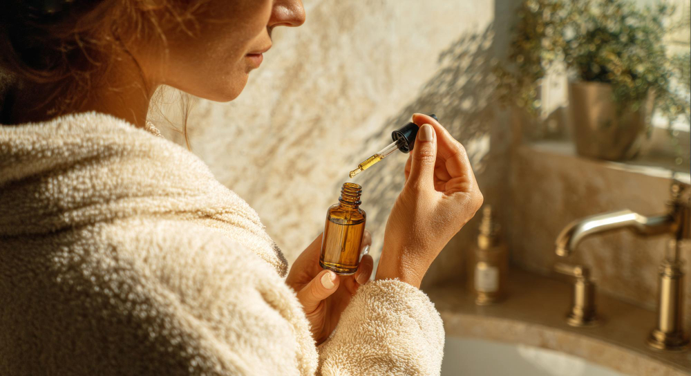 vrouw met flesje en druppelaar etherische olie