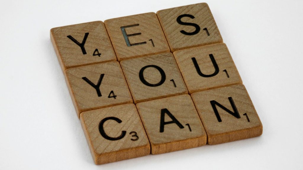 Scrabbleletters vormen motiverende boodschap die vertrouwen in nieuwe ervaringen uitstraalt